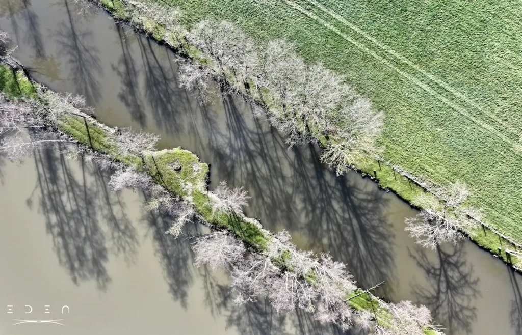 Photo vue du ciel d'une rivière qui passe au milieu d'un champ